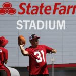 Arizona Cardinals fan Dwayne Anderson, right, throws a football in front of State Farm Stadium prior to an NFL football game against the Chicago Bears, Sunday, Sept. 23, 2018, in Glendale, Ariz. (AP Photo/Ralph Freso)