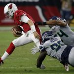Arizona Cardinals quarterback Josh Rosen, left, is tackled by Seattle Seahawks defensive tackle Jarran Reed (90) and linebacker Bobby Wagner (54) during the first half of an NFL football game, Sunday, Sept. 30, 2018, in Glendale, Ariz. (AP Photo/Ross D. Franklin)