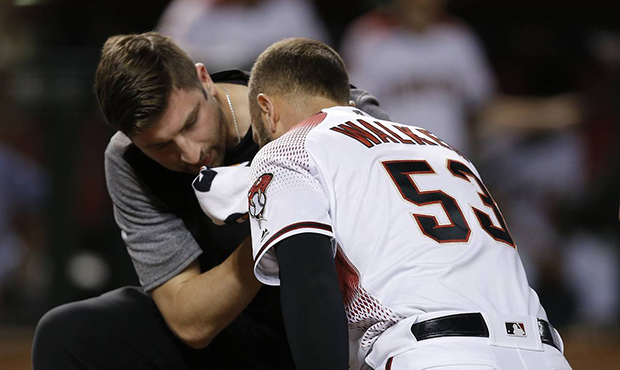 Arizona Diamondbacks' Christian Walker (53) is attended to by head athletic trainer Bryan DiPanfilo...