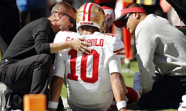 Trainers attend to San Francisco 49ers quarterback Jimmy Garoppolo (10) who was injured after a tac...
