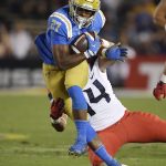 UCLA running back Joshua Kelley, left, runs the ball as Arizona defensive end Kylan Wilborn tries to tackle him during the first half of an NCAA college football game, Saturday, Oct. 20, 2018, in Pasadena, Calif. (AP Photo/Mark J. Terrill)