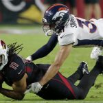 Arizona Cardinals wide receiver Larry Fitzgerald (11) is tackled by Denver Broncos free safety Justin Simmons (31) during the first half of an NFL football game, Thursday, Oct. 18, 2018, in Glendale, Ariz. (AP Photo/Rick Scuteri)