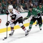 Arizona Coyotes defenseman Jordan Oesterle (82) tries to clear the puck as he is chased by Dallas Stars left wing Blake Comeau (15) during the first period of an NHL hockey game in Dallas, Thursday, Oct. 4, 2018. (AP Photo/Michael Ainsworth)