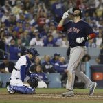 Los Angeles Dodgers catcher Austin Barnes waits at the plate as Boston Red Sox's J.D. Martinez scores after hitting a solo home run against Los Angeles Dodgers' Clayton Kershaw during the seventh inning in Game 5 of the World Series baseball game on Sunday, Oct. 28, 2018, in Los Angeles. (AP Photo/David J. Phillip)