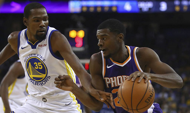 Phoenix Suns' Josh Jackson, right, drives the ball against Golden State Warriors' Kevin Durant (35)...