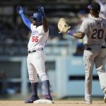 Los Angeles Dodgers' Yasiel Puig, left, reacts to his double as Colorado Rockies' Ian Desmond watches during the fourth inning of a tiebreaker baseball game, Monday, Oct. 1, 2018, in Los Angeles. (AP Photo/Jae C. Hong)
