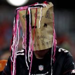 An Arizona Cardinals fan wears a bag on his head during the first half of an NFL football game against the Denver Broncos, Thursday, Oct. 18, 2018, in Glendale, Ariz. (AP Photo/Ralph Freso)