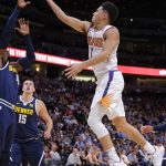 Phoenix Suns guard Devin Booker (1) goes up to shoot against Denver Nuggets forward Paul Millsap (4) during the first quarter of an NBA basketball game, Saturday, Oct. 20, 2018, in Denver. (AP Photo/Jack Dempsey)