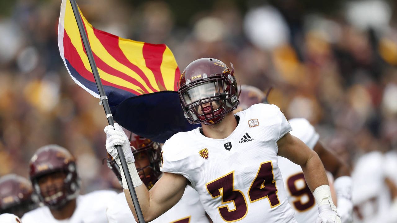 Arizona State linebacker Kyle Soelle carries out the state flag as the team takes the field to face...