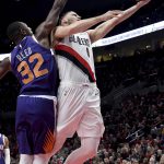 Portland Trail Blazers guard Nik Stauskas, right, drives to the basket against Phoenix Suns guard Davon Reed during the second half of an NBA preseason basketball game in Portland, Ore., Wednesday, Oct. 10, 2018. (AP Photo/Steve Dykes)