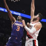 Phoenix Suns forward Trevor Ariza drives to the basket on Portland Trail Blazers center Jusuf Nurkic during the first half of an NBA preseason basketball game in Portland, Ore., Wednesday, Oct. 10, 2018. (AP Photo/Steve Dykes)