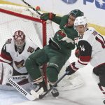 Minnesota Wild's Jordan Greenway, center, is checked by Arizona Coyotes' Richard Panik, right, of Slovakia as goalie Darcy Kuemper guards the net in the second period of an NHL hockey game Tuesday, Oct. 16, 2018, in St. Paul, Minn. (AP Photo/Jim Mone)