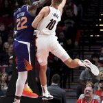 Portland Trail Blazers forward Jake Layman, right, drives to the basket on Phoenix Suns center Deandre Ayton during the first half of an NBA preseason basketball game in Portland, Ore., Wednesday, Oct. 10, 2018. (AP Photo/Steve Dykes)