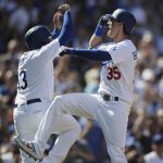 Los Angeles Dodgers' Cody Bellinger, right, celebrates his two-run home run with Max Muncy during the fourth inning of a tiebreaker baseball game against the Colorado Rockies, Monday, Oct. 1, 2018, in Los Angeles. (AP Photo/Jae C. Hong)