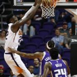 Phoenix Suns center Deandre Ayton, left, dunks against Sacramento Kings center Willie Cauley-Stein, back right, as Kings guard Buddy Hield (24) looks on during the first half of a preseason NBA basketball game Monday, Oct. 1, 2018, in Phoenix. (AP Photo/Ross D. Franklin)