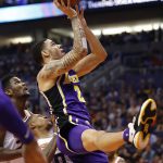 Los Angeles Lakers guard Lonzo Ball (2) shoots over Phoenix Suns guard Isaiah Canaan (0) and center Deandre Ayton during the first half of an NBA basketball game, Wednesday, Oct. 24, 2018, in Phoenix. (AP Photo/Matt York)