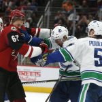 Arizona Coyotes left wing Lawson Crouse (67) and Vancouver Canucks left wing Antoine Roussel (26) battle in the second period during an NHL hockey game, Thursday, Oct. 25, 2018, in Glendale, Ariz. (AP Photo/Rick Scuteri)