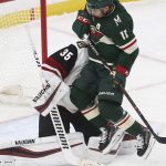Minnesota Wild's Zach Parise, right, jumps clear and into Arizona Coyotes' goalie Darcy Kuemper to make way for a shot in the first period of an NHL hockey game Tuesday, Oct. 16, 2018, in St. Paul, Minn. (AP Photo/Jim Mone)