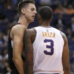 Portland Trail Blazers forward Zach Collins and Phoenix Suns forward Trevor Ariza (3) talk to each other from a close vantage point during the first half of an NBA preseason basketball game Friday, Oct. 5, 2018, in Phoenix. (AP Photo/Rick Scuteri)