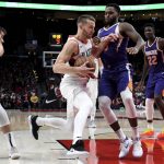 Portland Trail Blazers guard Nik Stauskas, center, drives to the basket on Phoenix Suns guard Troy Daniels as forward Dragan Bender, left, defends and Deandre Ayton, right, watches during the second half of an NBA preseason basketball game in Portland, Ore., Wednesday, Oct. 10, 2018. (AP Photo/Steve Dykes)