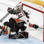 Arizona Coyotes goalie Antti Raanta (32) gets hammered by Anaheim Ducks' Kiefer Sherwood (64) after blocking his shot during the second period of an NHL hockey game Saturday, Oct. 6, 2018, in Glendale, Ariz. (AP Photo/Darryl Webb)