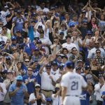 Fans cheer as Los Angeles Dodgers starting pitcher Walker Buehler, foreground, walks off the field after being relieved during the sixth inning of a tiebreaker baseball game against the Colorado Rockies, Monday, Oct. 1, 2018, in Los Angeles. (AP Photo/Jae C. Hong)