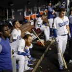 Members of the Los Angeles Dodgers watch from the dugout during the eighth inning in Game 5 of the World Series baseball game against the Boston Red Sox on Sunday, Oct. 28, 2018, in Los Angeles. (AP Photo/David J. Phillip)