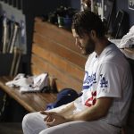 Los Angeles Dodgers starting pitcher Clayton Kershaw sits in the dugout during the seventh inning in Game 5 of the World Series baseball game against the Boston Red Sox on Sunday, Oct. 28, 2018, in Los Angeles. (AP Photo/Jae C. Hong)