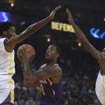 Phoenix Suns' Trevor Ariza, center, looks to shoot between Golden State Warriors' Damian Jones (15) and Kevin Durant, right, during the first half of a preseason NBA basketball game Monday, Oct. 8, 2018, in Oakland, Calif. (AP Photo/Ben Margot)