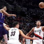 Phoenix Suns guard Shaquille Harrison, left, passes the ball over Portland Trail Blazers forward Zach Collins, center, and guard Wade Baldwin IV, right, during the first half of an NBA preseason basketball game in Portland, Ore., Wednesday, Oct. 10, 2018. (AP Photo/Steve Dykes)