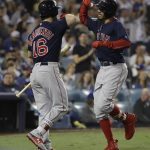 Boston Red Sox's Mookie Betts celebrates with Andrew Benintendi after hitting a solo home run against Los Angeles Dodgers' Clayton Kershaw during the sixth inning in Game 5 of the World Series baseball game on Sunday, Oct. 28, 2018, in Los Angeles. (AP Photo/David J. Phillip)
