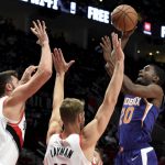 Phoenix Suns forward Josh Jackson, right, shoots over Portland Trail Blazers center Jusuf Nurkic, left, and forward Jake Layman during the first half of an NBA preseason basketball game in Portland, Ore., Wednesday, Oct. 10, 2018. (AP Photo/Steve Dykes)