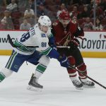 Arizona Coyotes defenseman Jason Demers gets called for hooking on Vancouver Canucks center Adam Gaudette (88) in the third period during an NHL hockey game, Thursday, Oct. 25, 2018, in Glendale, Ariz. Arizona defeated Vancouver 4-1. (AP Photo/Rick Scuteri)