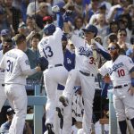 Los Angeles Dodgers' Max Muncy, center left, celebrates his two-run home run with Cody Bellinger during the fifth inning of a tiebreaker baseball game against the Colorado Rockies, Monday, Oct. 1, 2018, in Los Angeles. (AP Photo/Jae C. Hong)