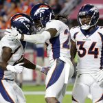 Denver Broncos cornerback Bradley Roby celebrates his touchdown against the Arizona Cardinals with cornerback Isaac Yiado, left, and defensive back Will Parks (34) during the second half of an NFL football game, Thursday, Oct. 18, 2018, in Glendale, Ariz. (AP Photo/Rick Scuteri)