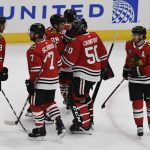 Chicago Blackhawks goaltender Corey Crawford (50) is greeted by his teammates after playing in first game after an injury in an NHL hockey game against the Arizona Coyotes Thursday, Oct. 18, 2018, in Chicago. The Coyotes won 4-1. (AP Photo/David Banks)