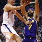 Phoenix Suns guard Devin Booker (1) shoots over Los Angeles Lakers center JaVale McGee (7) during the second half of an NBA basketball game, Wednesday, Oct. 24, 2018, in Phoenix. Booker was injured on the play and left the game. (AP Photo/Matt York)