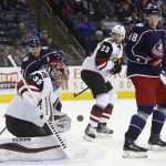 Arizona Coyotes' Darcy Kuemper, front, makes a save as teammate Oliver Ekman-Larsson, center, of Sweden, and Columbus Blue Jackets' Cam Atkinson, left, and Pierre-Luc Dubois look for the rebound during the second period of an NHL hockey game, Tuesday, Oct. 23, 2018, in Columbus, Ohio. (AP Photo/Jay LaPrete)