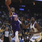 Phoenix Suns' Shaquille Harrison, left, lays up a shot past Golden State Warriors' Kevon Looney (5) during the first half of a preseason NBA basketball game Monday, Oct. 8, 2018, in Oakland, Calif. (AP Photo/Ben Margot)