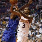 Phoenix Suns forward Trevor Ariza (3) passes around Dallas Mavericks center DeAndre Jordan during the second half of an NBA basketball game, Wednesday, Oct. 17, 2018, in Phoenix. The Suns won 121-100. (AP Photo/Matt York)