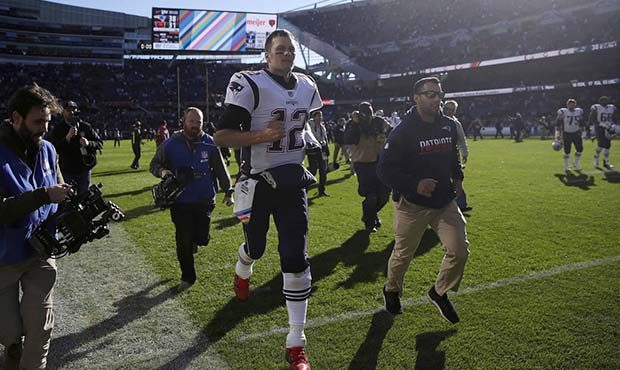 New England Patriots quarterback Tom Brady (12) runs off the field after an NFL football game again...