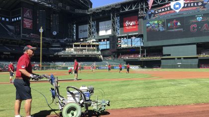 The grounds crew at Chase Field prepares the field prior to a spring training baseball game between...