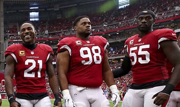 Patrick Peterson (21), Corey Peters (98) and Chandler Jones (55) wait for the coin toss prior to an...