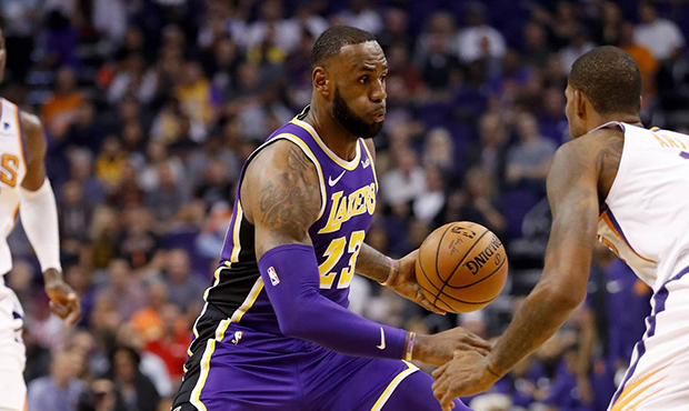 Los Angeles Lakers forward LeBron James (23) drives past Phoenix Suns forward Trevor Ariza during t...