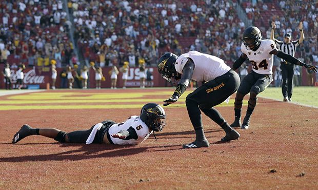 Arizona State quarterback Manny Wilkins, bottom, left, celebrates with teammates in the end zone af...