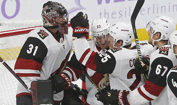 Arizona Coyotes goalie Adin Hill, left, is congratulated by teammates after the Coyotes defeated th...