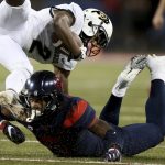 Arizona's Christian Young (5) makes a shoestring tackle of Colorado's Ronnie Blackmon (2) on a kickoff return during the second quarter of an NCAA college football game Friday, Nov. 2, 2018, in Tucson, Ariz. (Kelly Presnell/Arizona Daily Star via AP)