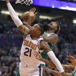 Boston Celtics guard Marcus Smart is fouled by Phoenix Suns forward Richaun Holmes (21) during the first half of an NBA basketball game, Thursday, Nov. 8, 2018, in Phoenix. (AP Photo/Matt York)