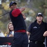 Tiger Woods hits off the 16th tee as Phil Mickelson watches during a golf match at Shadow Creek golf course, Friday, Nov. 23, 2018, in Las Vegas. (AP Photo/John Locher)