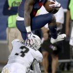 Arizona running back J.J. Taylor (21) tries to jump out of the arms of Colorado defensive back Derrion Rakestraw (3) during the first quarter of an NCAA college football game Friday, Nov. 2, 2018, in Tucson, Ariz. (Kelly Presnell/Arizona Daily Star via AP)
